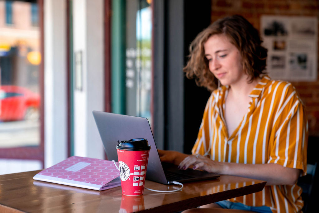 Five Lakes guest with a red coffee cup in a coffee house